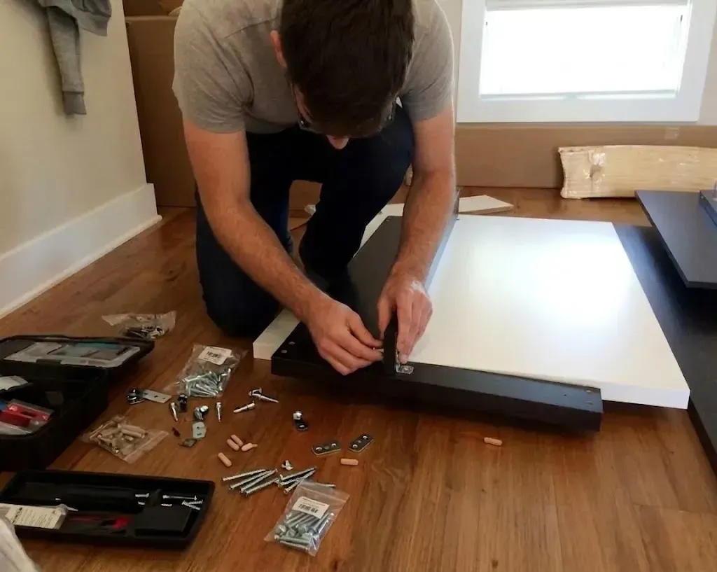 Professional furniture assembler organizing flat-pack hardware before starting
