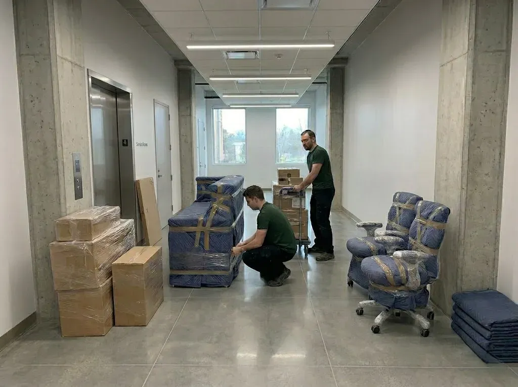 Professional movers securing assets in a corporate hallway