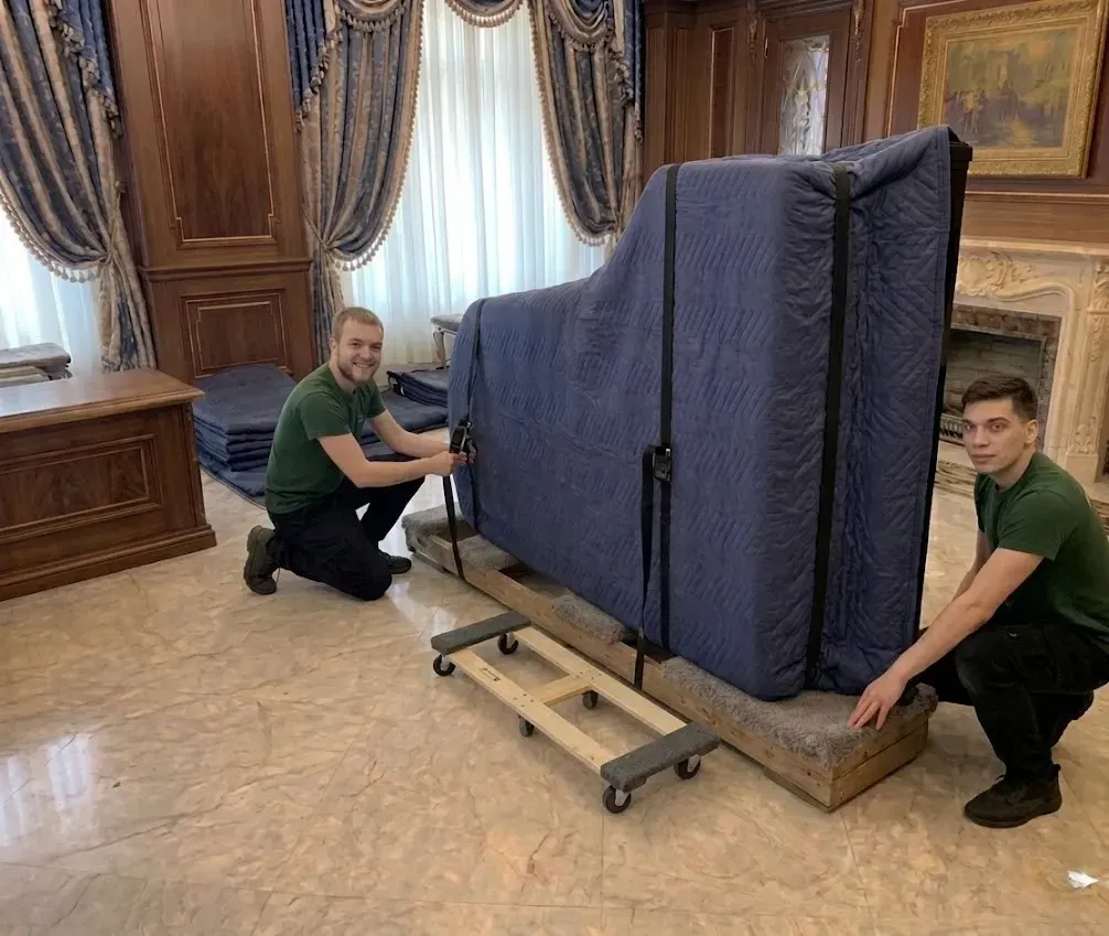 Grand piano resting on its side on a specialized piano skid board
